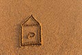 The house is drawn on the sand. drawing of a house on the beach, safety and relaxation concept Royalty Free Stock Photo