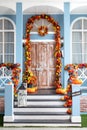 House entrance staircase decorated for autumn holidays. Cozy wooden porch of the house with pumpkins in fall time. Royalty Free Stock Photo