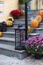 House entrance staircase decorated for autumn holidays, fall flowers and pumpkins. Cozy porch of the house with vintage lanterns i Royalty Free Stock Photo