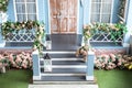 House entrance staircase at home in summer day. Wooden porch of house with different flowers. Terrace of Spring house. Royalty Free Stock Photo