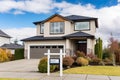 House exterior with entrance sign and blue sky background. Northwest, USA, Real estate home for sale sign hanging in front of the Royalty Free Stock Photo