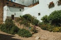 House facade with white walls, stairs, flower pots and plants at Caceres