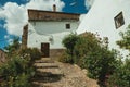 House facade with white walls, stairs, flower pots and plants at Caceres