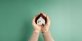 House and Family Insurance Concepts. Hand Holding a Wooden Toy House with Love and Gentle Care. Customer Care. Top View with More Royalty Free Stock Photo