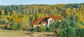 House in the forest in autumn, beautiful colors of the trees