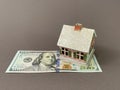 House with a foundation on a hundred dollar bill. A toy house with a roof costs money. Concept: mortgage, purchase, sale of real Royalty Free Stock Photo