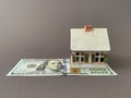 House with a foundation on a hundred dollar bill. A toy house with a roof costs money. Concept: mortgage, purchase, sale of real Royalty Free Stock Photo