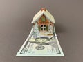 House with a foundation on a hundred dollar bill. A toy house with a roof costs money. Concept: mortgage, purchase, sale of real Royalty Free Stock Photo