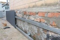 House foundation wall renovation with waterproofing metal sheets protection from rain