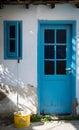 House front entrance with blue closed door an open window and a yellow mop Royalty Free Stock Photo