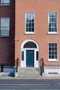 House front with stairs red door, brick stone, and glass windows Royalty Free Stock Photo