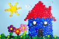 House with garden mosaic decoration made of colorful plastic bottle cups. Handmade kids craft. Recycling art Royalty Free Stock Photo