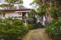 a house with a garden and a pathway leading to it and a tree lined path leading to it