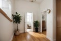 House hallway entrance interior with stairs and furniture. Apartment background with door, mirror, bag on hanger, flower in vase, Royalty Free Stock Photo