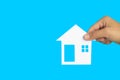 The house in human hands on blue background, Real estate concept, Mortgage property home concept, Copy space