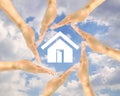 House icon in the hands of people on a background of clouds Royalty Free Stock Photo