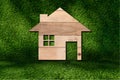 a house icon from wooden texture on grass background Royalty Free Stock Photo