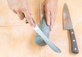 House keeper shapening kitchen knife with pestle stone
