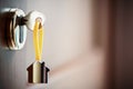 House key in the door. Close House key on a house shaped silver keyring in the lock of a entrance brown door Royalty Free Stock Photo