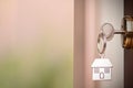 House key in the door. Close House key on a house shaped silver keyring in the lock of a entrance brown door