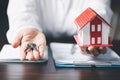 House key in hand, Key with model home on wooden table, Save money concept, Property investment, house loan, reverse mortgage, Royalty Free Stock Photo