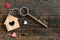 House key in heart shape with home keyring on old wood background decorated with mini heart Royalty Free Stock Photo