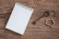 House key with home keyring, blank notebook and pencil on old wood table background Royalty Free Stock Photo