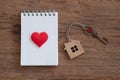 House key with home keyring, blank notebook and pencil on old wood table background Royalty Free Stock Photo