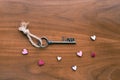House key with home keyring decorated with mini heart on rusty wood background Royalty Free Stock Photo
