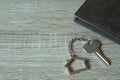 House key with home keyring and wallet on wood table Royalty Free Stock Photo