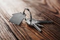 House key on house shaped keychain on wooden floorboards