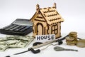 Model of a wooden house with a key, money and a calculator. real estate, mortgage and investment concept. Royalty Free Stock Photo