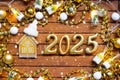 House key with tiny figure of home mock up on festive brown wooden background, lights of garlands. New Year 2025 wooden letters,