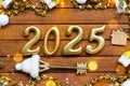 House key with tiny figure of home mock up on festive brown wooden background, lights of garlands. New Year 2025 wooden letters,