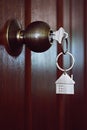 House key in wooden front door Royalty Free Stock Photo