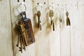 House key with wooden home keyring hanging on wood board background, property concept, copy space Royalty Free Stock Photo