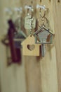 House key with wooden home keyring hanging on wood board background, property concept, copy space Royalty Free Stock Photo