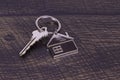 House Keychain With Key On A Wooden Background