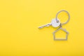 House keys with trinket on color background, top view with copy space