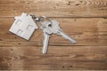 House keys with trinket on wooden background