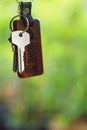 House keys with wooden home keyring with green garden background, property concept, copy space Royalty Free Stock Photo