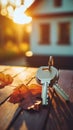 House keys on a wooden surface with a warm sunset and home in the background. Concept of new home ownership, real estate Royalty Free Stock Photo