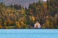 House by lake, autumn forest and mountains Royalty Free Stock Photo