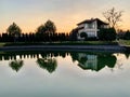 House by the lake. Reflection of a house in the water. Mansion by the river at sunset. The cottage is near the reservoir. Kiev Royalty Free Stock Photo