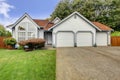 House with large arch window and three car garage