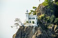 House with lighthouse on rock Royalty Free Stock Photo