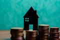 A house made of blackboard and a stack of euro coins in a green Royalty Free Stock Photo