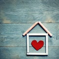 House made of chalk with red heart in it on blue wooden background. Sweet home concept. Mortgage