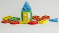 The house is made of children`s wooden blocks of different colors and shapes. colorful figures are stacked in the house on a white Royalty Free Stock Photo