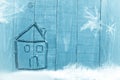House made from dry sticks on wooden, blue background.Investments. Snow and snow flaks image.